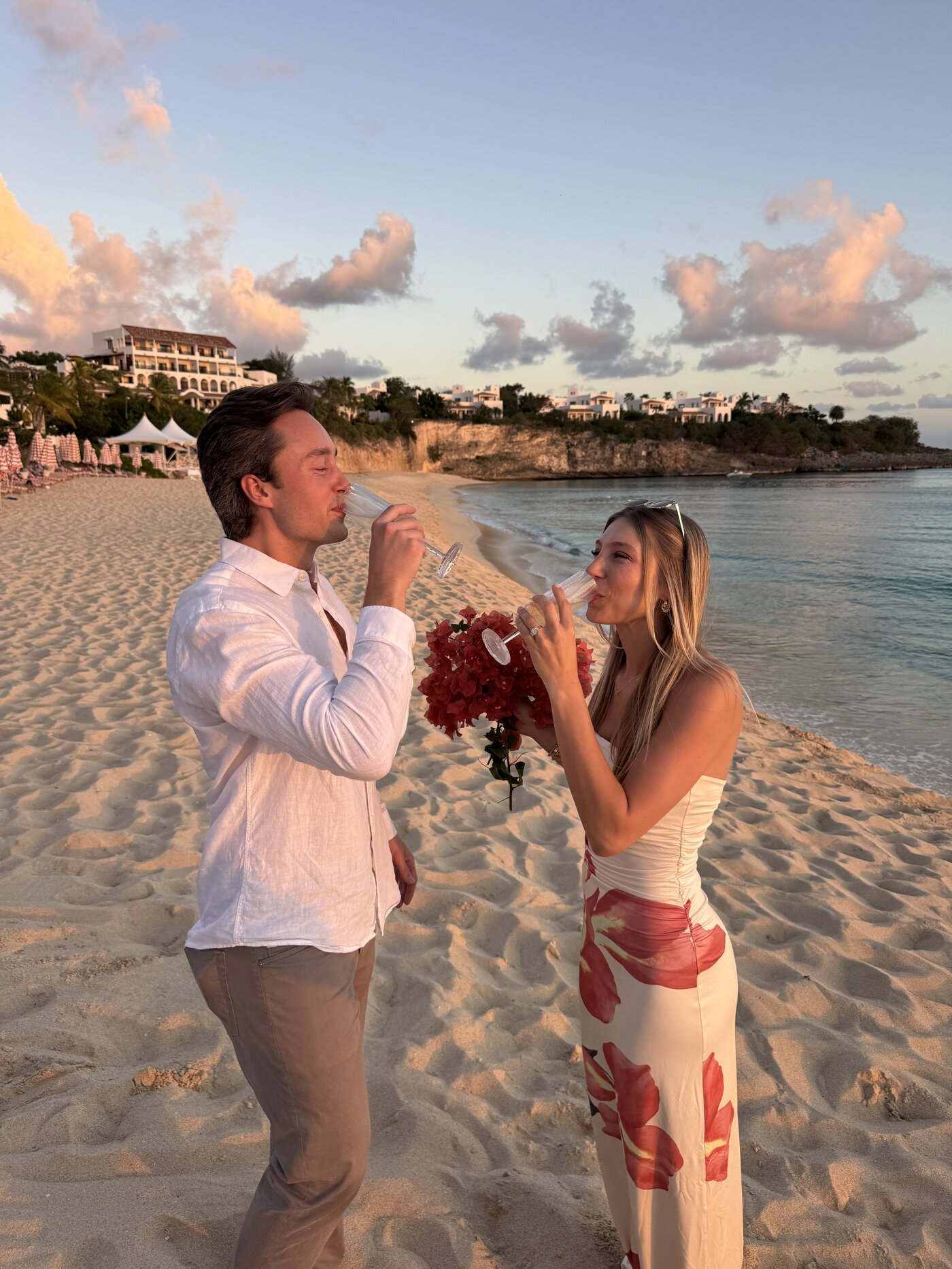 Charlsey and Andrew with champagne at sunset on Anse Marcel beach